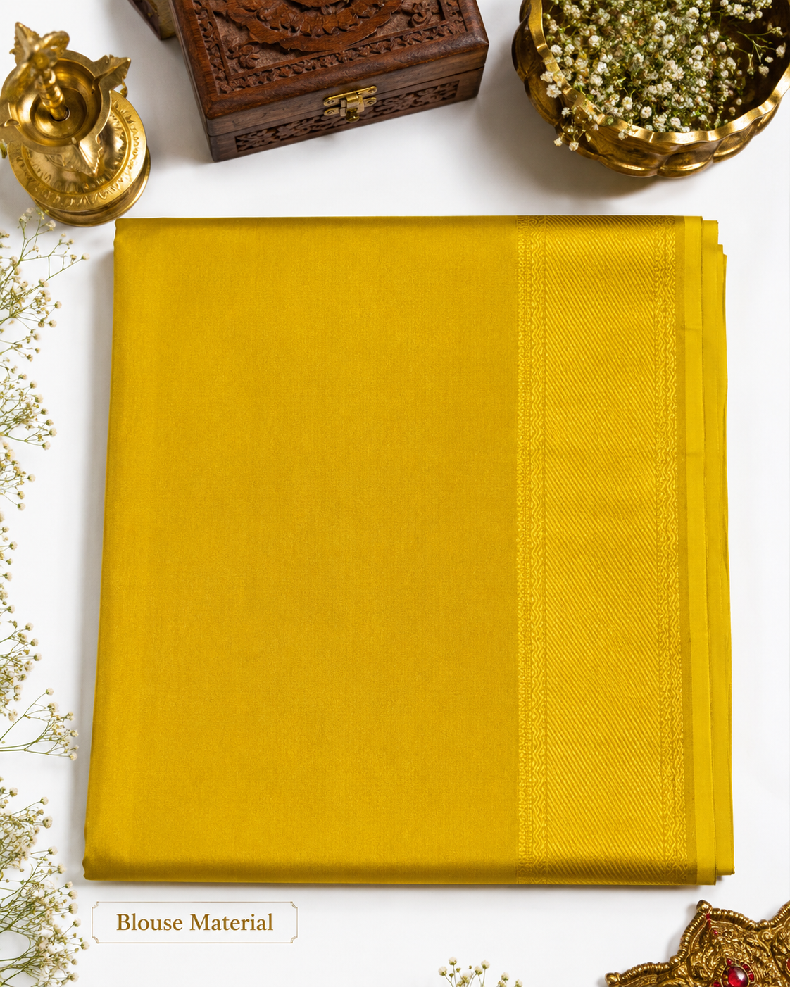 Yellow fabric swatch with decorative items on a white background