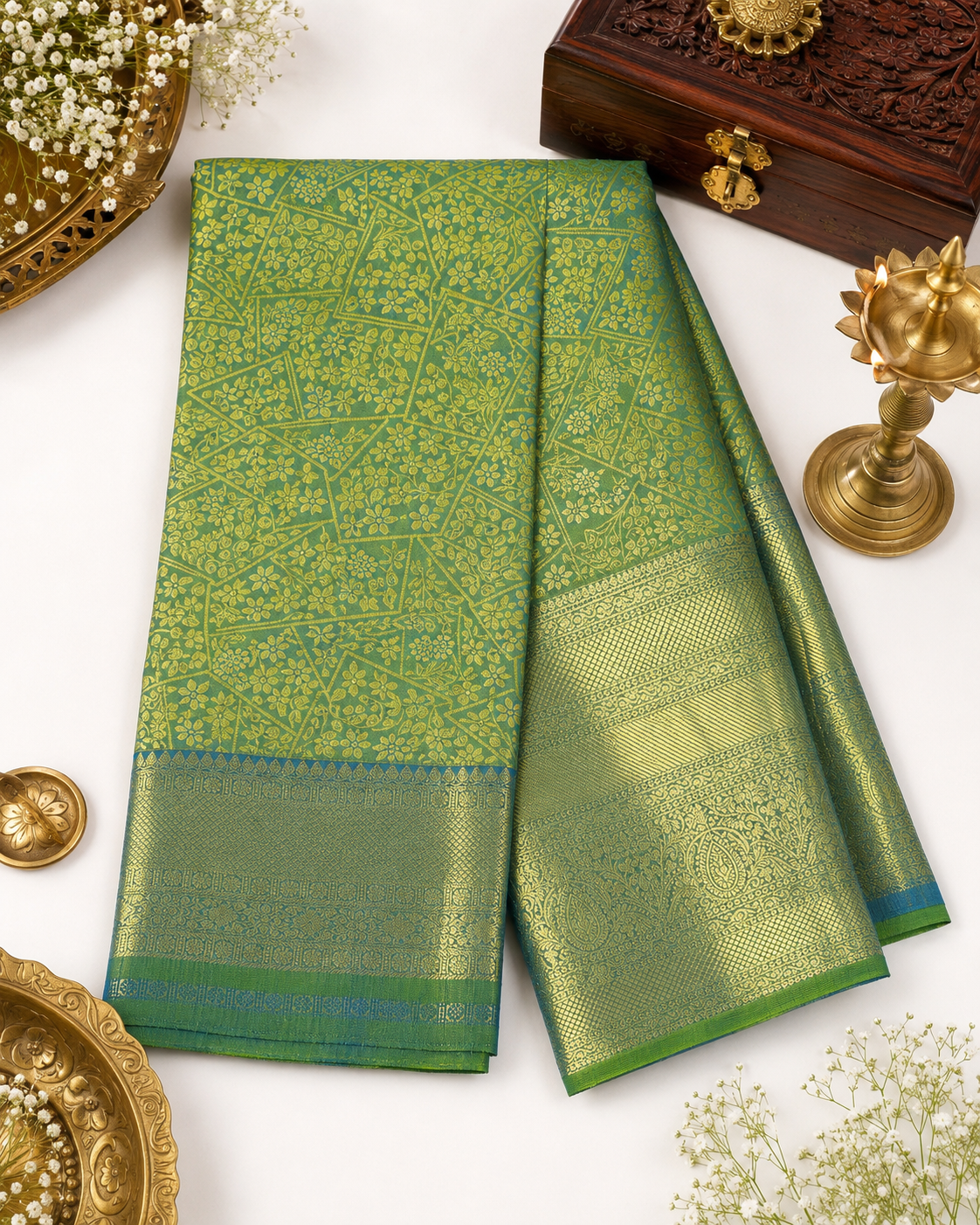 Green saree with gold patterns on a white background