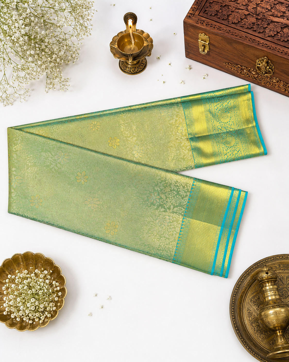 Green and gold saree with decorative elements on a white background